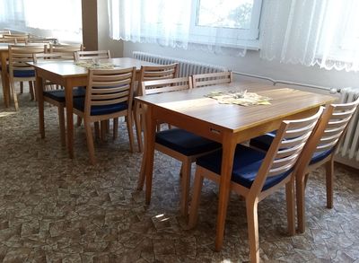 Dřevěné židle s čalouněním s odolnou látkou. J9delní dřevěné židle pro domovy seniorů s možností stohování.